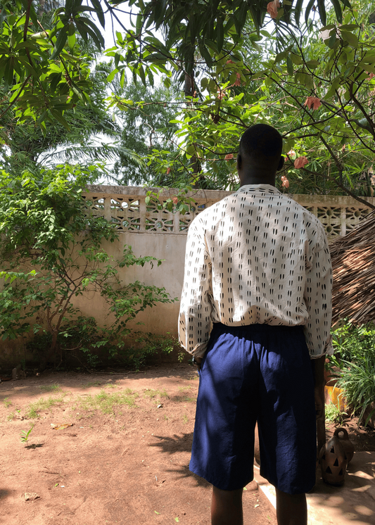 Short oversize ISMAEL bleu nuit porté de dos avec une chemise claire à motifs noirs, montrant sa coupe ample