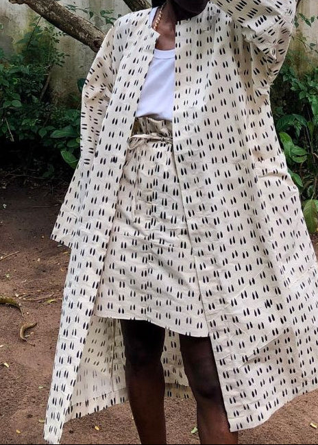Gros plan sur mini-jupe MATHILDE en coton béninois beige à motifs noirs, portée avec un kimono assorti et un débardeur blanc