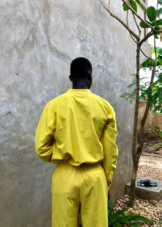 Short oversize ISMAEL en coton béninois jaune, porté de dos avec une chemise assortie